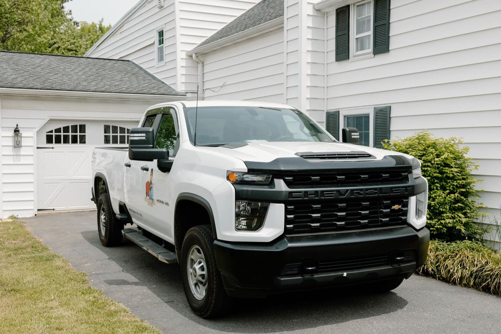 She Does Hauling branded white truck parked in a residential driveway, ready for a junk removal job